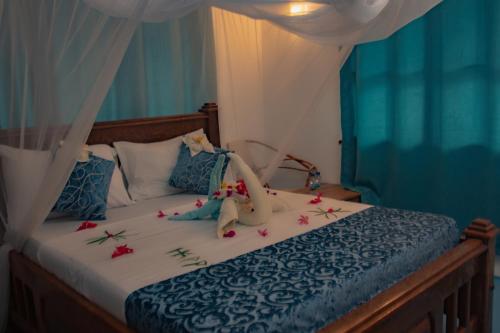 江比阿HA Beach Hotel Zanzibar的一间卧室,床上放着鲜花