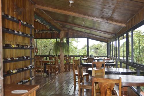 蒙泰韦尔德哥斯达黎加Belcruz family lodge的用餐室设有桌椅和窗户。