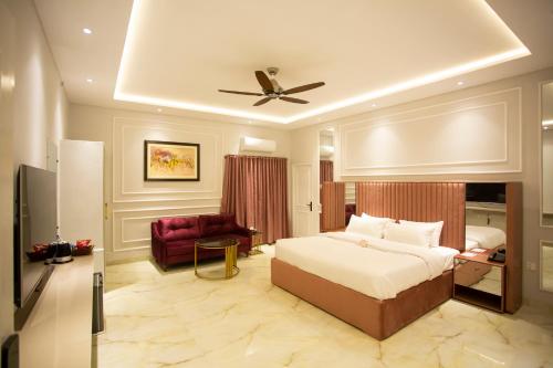 巴哈瓦尔布尔The Edition Bahawalpur的一间卧室配有一张床、一张沙发和吊扇。