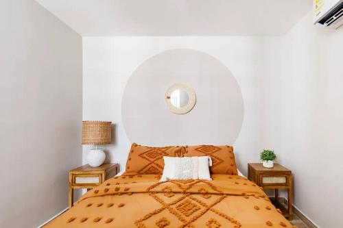 巴兰基亚Apart tranquilo y comodo al lado de playa y mall plaza的一间卧室配有一张带橙色床罩的床