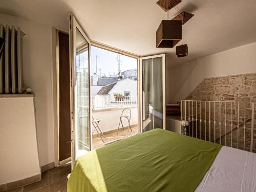 马丁纳弗兰卡Martine Dimore Storiche di Puglia的一间带绿色床的卧室和一个阳台