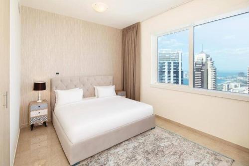 迪拜Marina One Bedroom - KV Hotels的卧室设有白色的床和大窗户