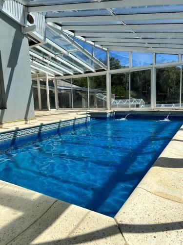 圣卡洛斯-德巴里洛切Casa con pileta climatizada privada的大楼内一个蓝色的大型游泳池