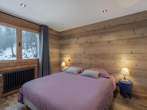 梅杰夫CHALET " JEANE " proche centre的一间卧室设有一张床和木墙