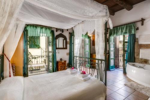 干尼亚IFIGENIA TRAD.ROOMS IN OLDTOWN BY.MARIOS的一间卧室设有一张大床和一个浴缸