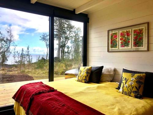 Puerto ClockerCalma Cabins的一间卧室设有一张床和一个大窗户