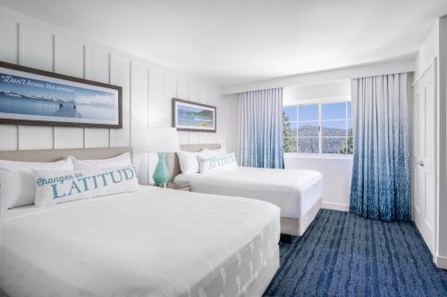 南太浩湖Margaritaville Resort Lake Tahoe的酒店客房设有两张床和窗户。