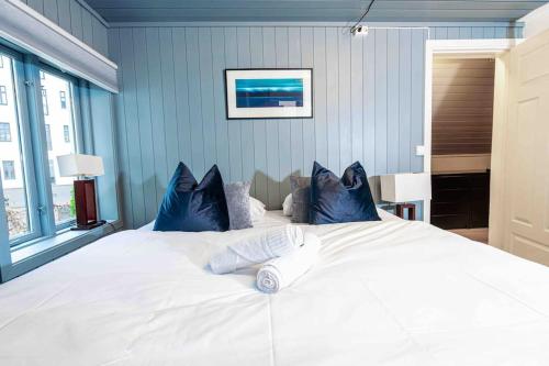 奥斯陆Unique Experience in Oslo's Heart的卧室配有带蓝色枕头的大型白色床