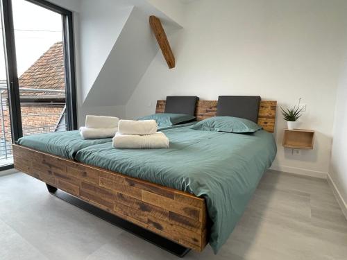 DuppigheimLes Duplex Solaires的一间卧室设有一张木床和大窗户