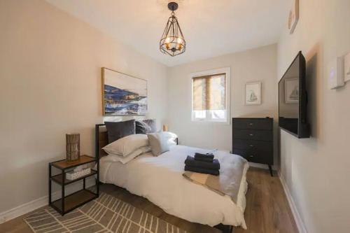 多伦多Casa Hotels的一间卧室配有一张床、一台电视和吊灯。