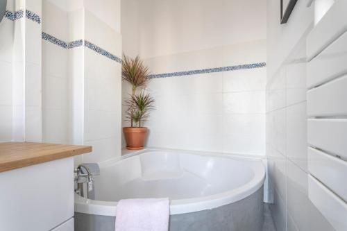 马赛Calme, soleil, plage - Catalans的带浴缸和盆栽的浴室