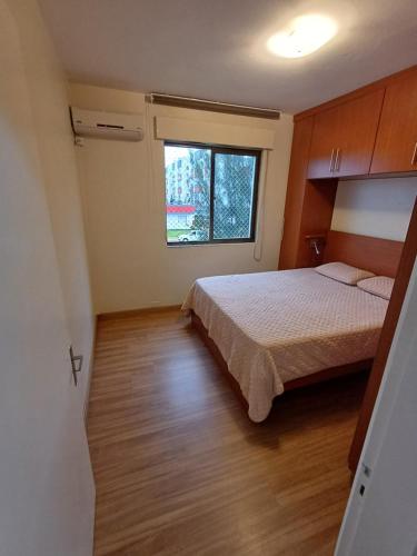 卡庞达卡诺阿Ap dos primos的一间卧室设有一张床和一个窗口