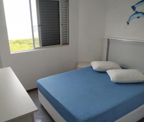 巴拉那州蓬塔尔Apartamento de cobertura na beira mar e de frente para o mar. Vista maravilhosa.的一间卧室设有蓝色的床和窗户。