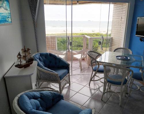 巴拉那州蓬塔尔Apartamento de cobertura na beira mar e de frente para o mar. Vista maravilhosa.的客厅配有桌椅,享有海景。