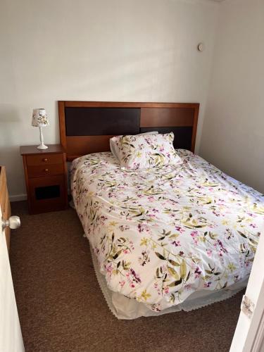 奥索尔诺Casa a 10 minutos del centro Osorno的一间卧室配有一张带花卉床罩的床