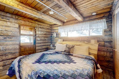 陶斯滑雪谷Ridgerunner Cabin的小木屋内一间卧室,配有一张床