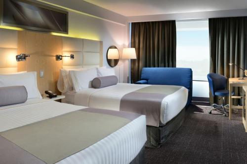 普埃布拉Gran Hotel de Puebla by HNF的酒店客房,配有两张床和椅子