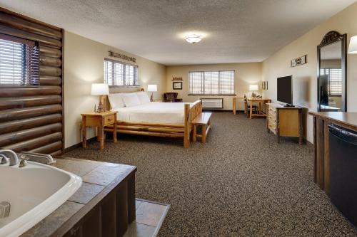 莫林Stoney Creek Hotel Moline的一间卧室配有一张床,浴室设有浴缸
