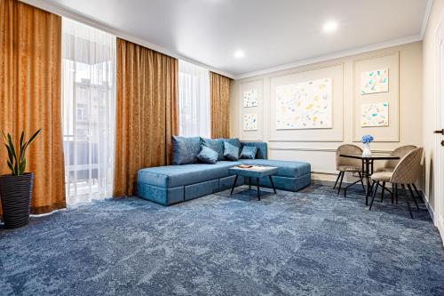 伊万诺-弗兰科夫斯克ApartReserve Avtorskiy的客厅配有蓝色的沙发和桌子