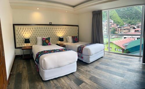 马丘比丘Jaya Machu Picchu Boutique Hotel的酒店客房设有两张床和大窗户。