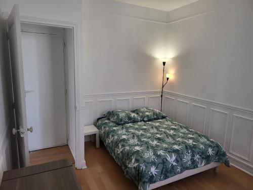 圣吉欧梅斯Appartement Accueillant的卧室配有一张床和一盏灯,位于门边