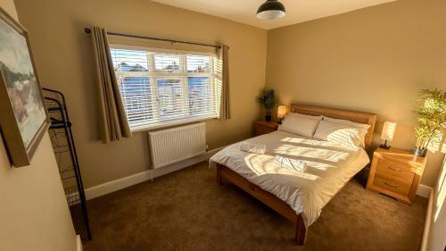 克利索普斯Sandy Shores Holiday Home的一间卧室设有一张大床和一个窗户。
