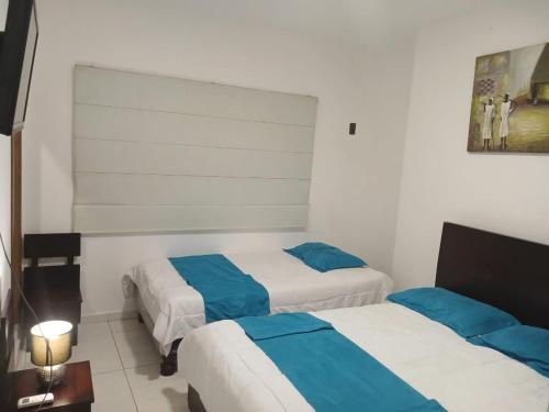 曼塔Hotel Mykonos Manta的蓝色和白色的酒店客房内的两张床