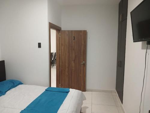 曼塔Hotel Mykonos Manta的一间卧室配有一张床和一扇木门