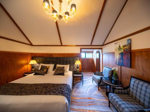 罗托鲁瓦Hana Lodge的酒店客房带一张床、一张沙发和一个吊灯
