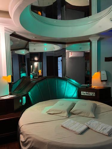 阿拉萨图巴Espacial Motel的一间卧室配有一张带绿色床头板的床