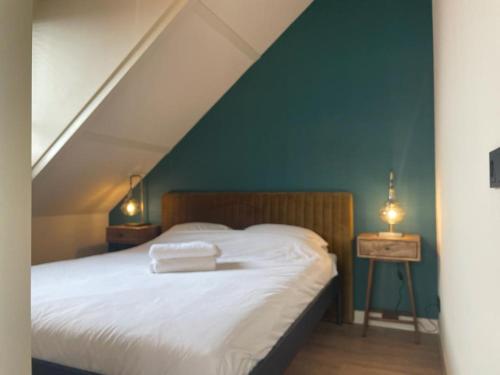 科特海讷De Nieuwe Poort Kortgene的一间卧室配有一张蓝色墙壁的床