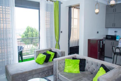 坎帕拉Cozy Oasis的客厅配有两张沙发和绿色枕头