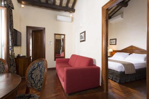 罗马缇亚特洛佩斯酒店的一间卧室配有一张床和一张红色椅子