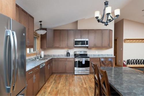 维勒蒙特Mama Bear的厨房配有木制橱柜和不锈钢冰箱。
