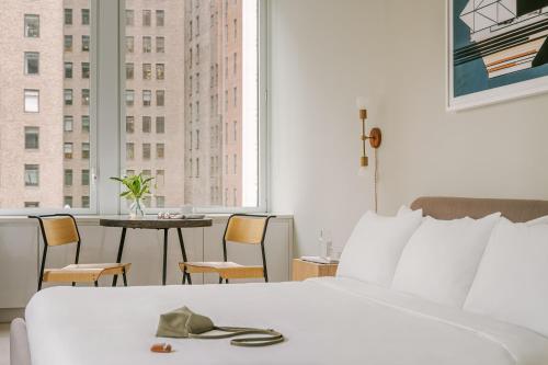 纽约Sonder Battery Park的酒店客房,配有一张床和一张桌子及椅子