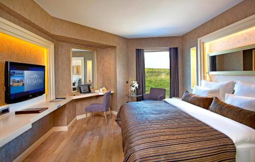 伊斯坦布尔利马克欧亚豪华酒店的酒店客房设有一张大床和一张书桌。