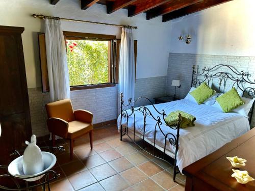 Realejo AltoCasa con jardín y jacuzzi的卧室配有床、椅子和窗户。