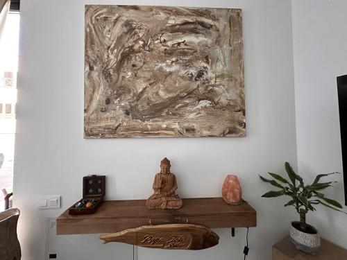宏达海滩Papá Totë Deluxe的坐在一张桌子上的佛陀,在一幅画里
