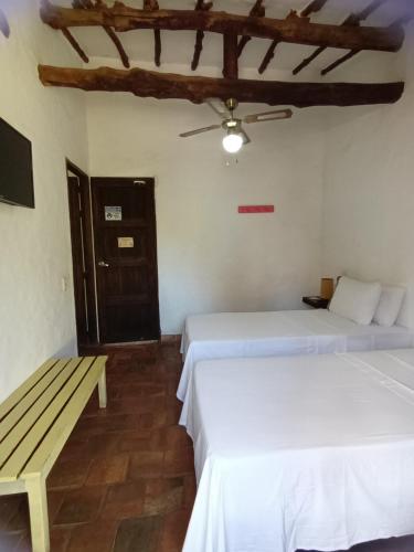 巴里查拉Casona CHARA的配有2张床的带长凳和天花板的客房