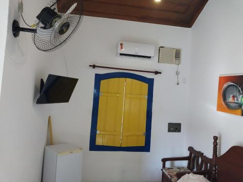 帕拉蒂Pousada Flores da Terra的一间设有黄色门和风扇的客房