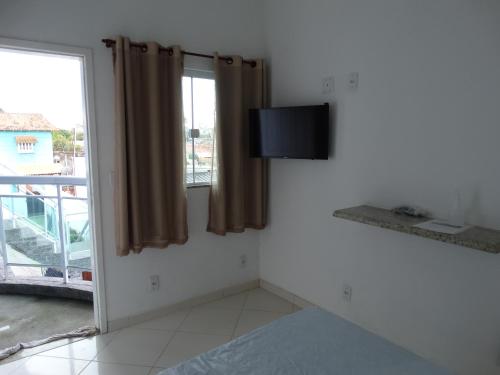 TamoiosNacif&Alcantara Suítes的客房设有床、电视和窗户。