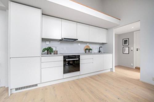 奥斯陆Apartment in Greenland, Oslo的白色的厨房配有白色的橱柜和桌子