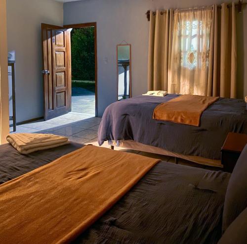 科万Hotel Xucaneb的一间卧室设有两张床,并设有一个通往庭院的门。