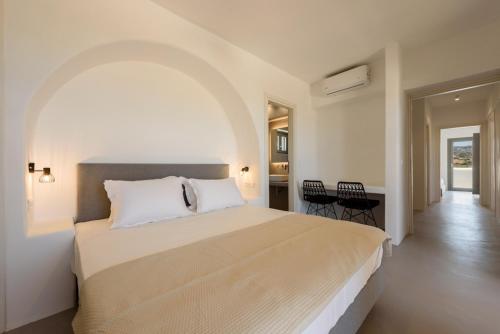 MármaraAegean Gem Villa with private pool in Paros的一间卧室配有一张大床和一张桌子及椅子