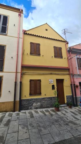 伊格莱西亚斯Casa vacanze Galena的黄色建筑,上面有棕色百叶窗