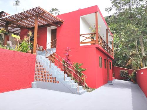 伊利亚贝拉Apartamento em Ilha bela的一座红色的房子,前面有楼梯