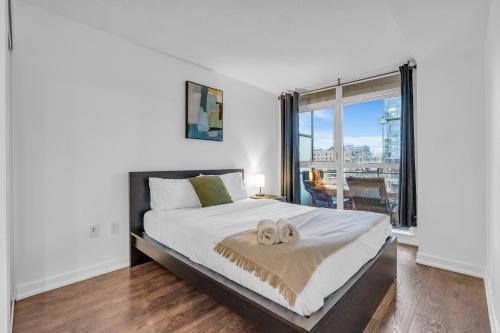 多伦多Cityplace Luxury suites的一间卧室设有一张大床和一个大窗户