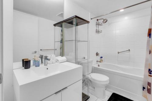 多伦多Cityplace Luxury suites的白色的浴室设有卫生间和浴缸。