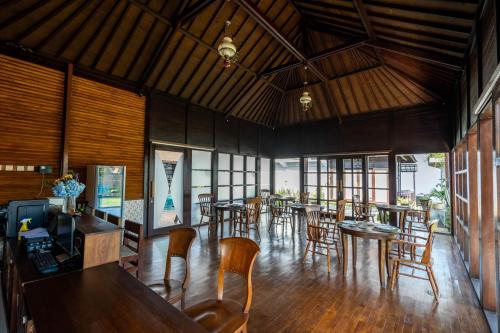 姆杜克Shankara Munduk Bali的用餐室设有桌椅和窗户。
