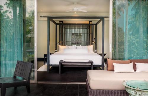 苏林海滩Twinpalms Phuket的一间卧室配有一张床和一张沙发